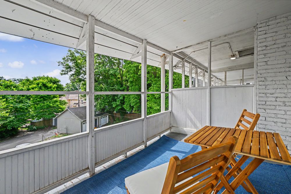 Covered porch with wooden bistro table overlooking the treetops